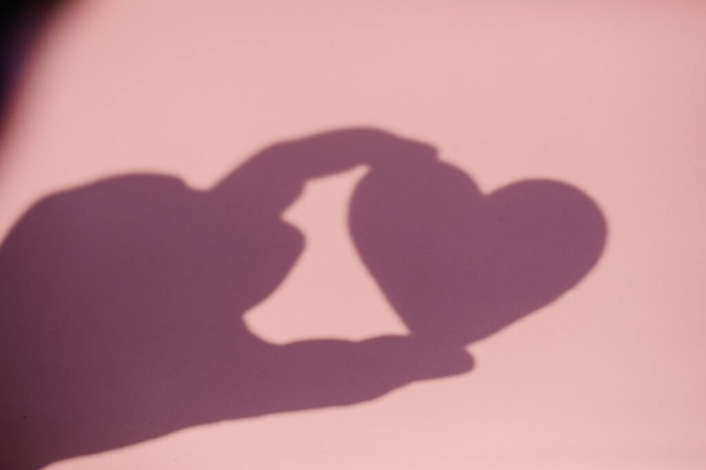 shadow of a hand holding a heart shape object