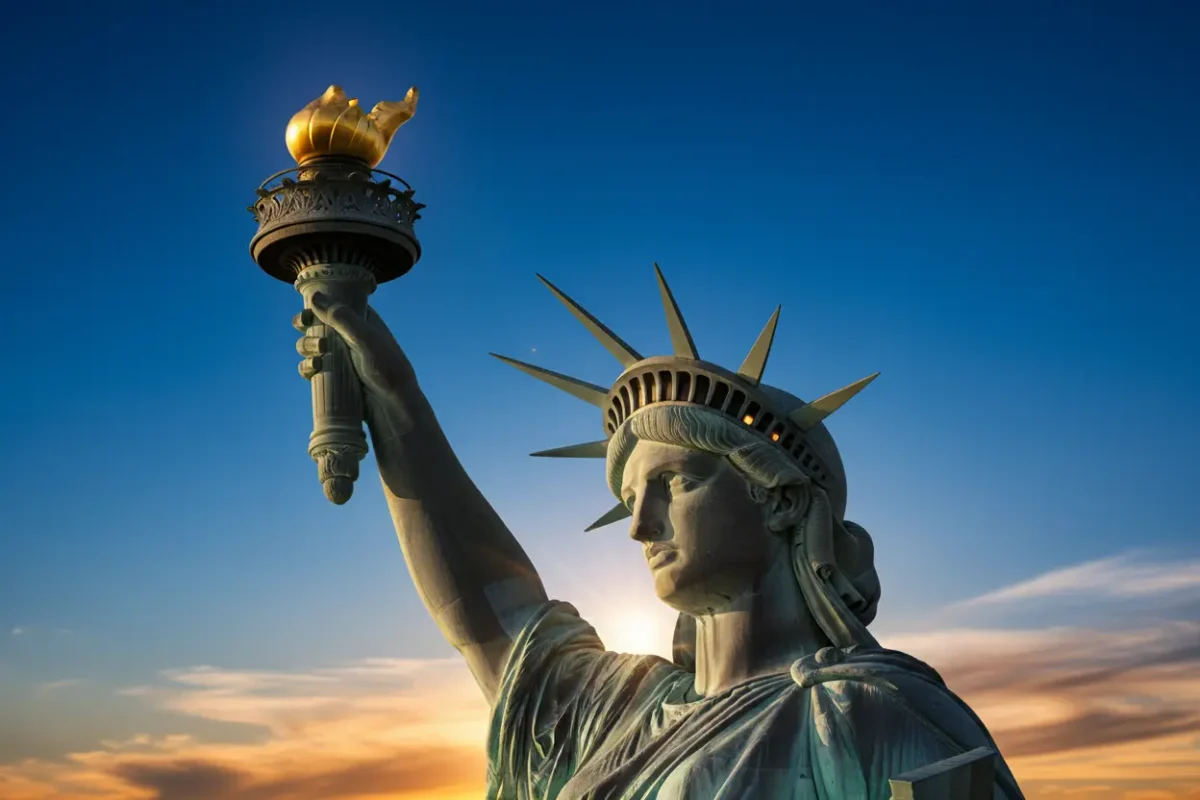 Detalhes da tocha e coroa da Estátua da Liberdade, banhadas pela luz do entardecer.